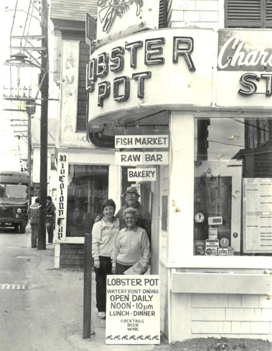 Vintage black-and-white photo of the Lobster Pot storefront with owners out front